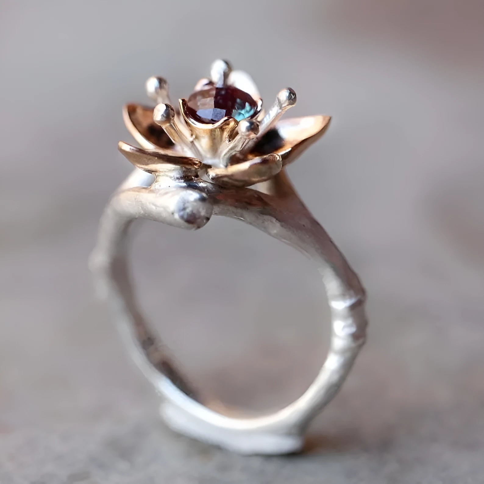 Silver two-tone floral geometric alloy ring for women on a grey background, showing detail.