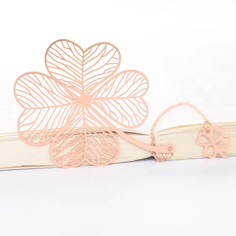 Brass metal bookmark with hollow leaf design and rose gold tassel in a presentation box.