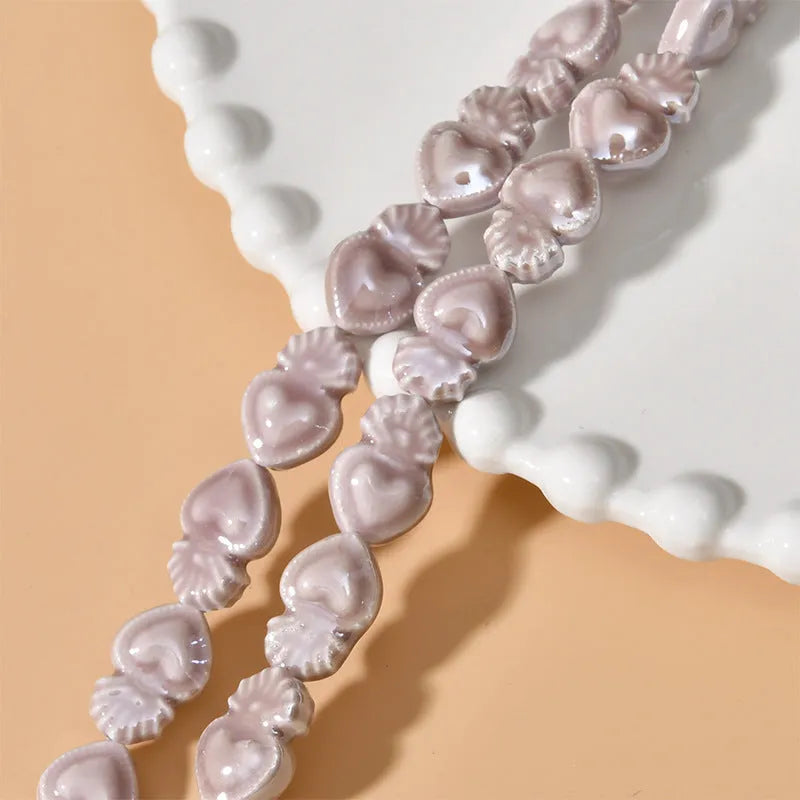 Assorted small ceramic torch beads in multiple colours on a white background.