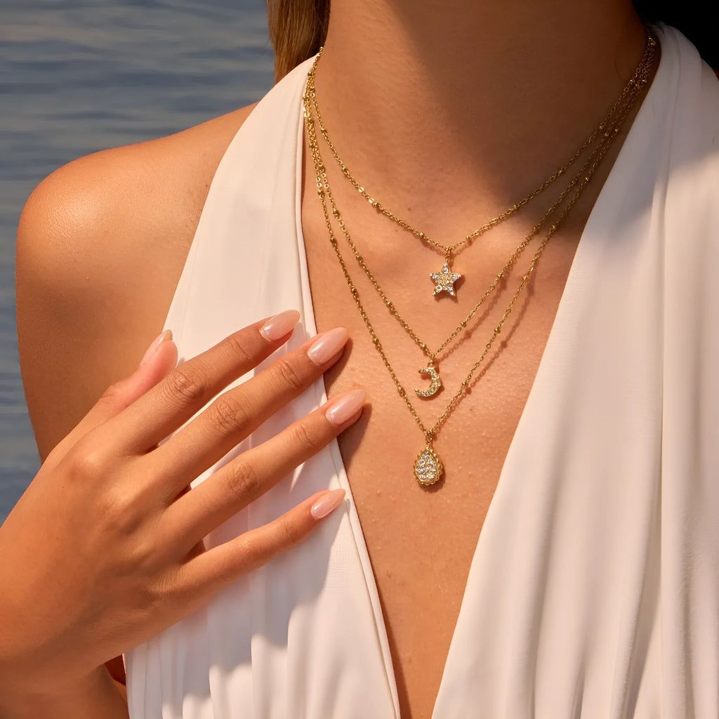 Set of three stainless steel geometric pendant necklaces with 18K electroplating: star, moon, and water drop shapes on regular chains.