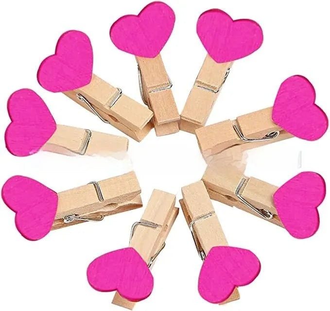 Set of five solid wood heart-shaped clips in red, white, and rose red on a plain surface.