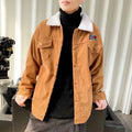 Man wearing a loose-fit khaki corduroy work jacket with side pockets.