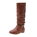Women's flat heel black slip-on boots with round toe and high cylinder shaft.