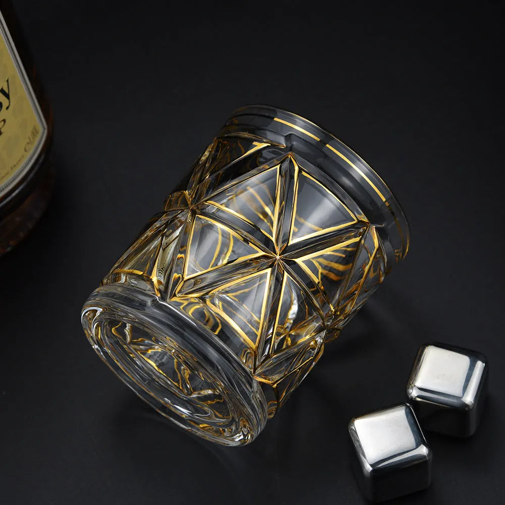 Crystal glass whiskey shot glass with solid gold finish on a bar counter
