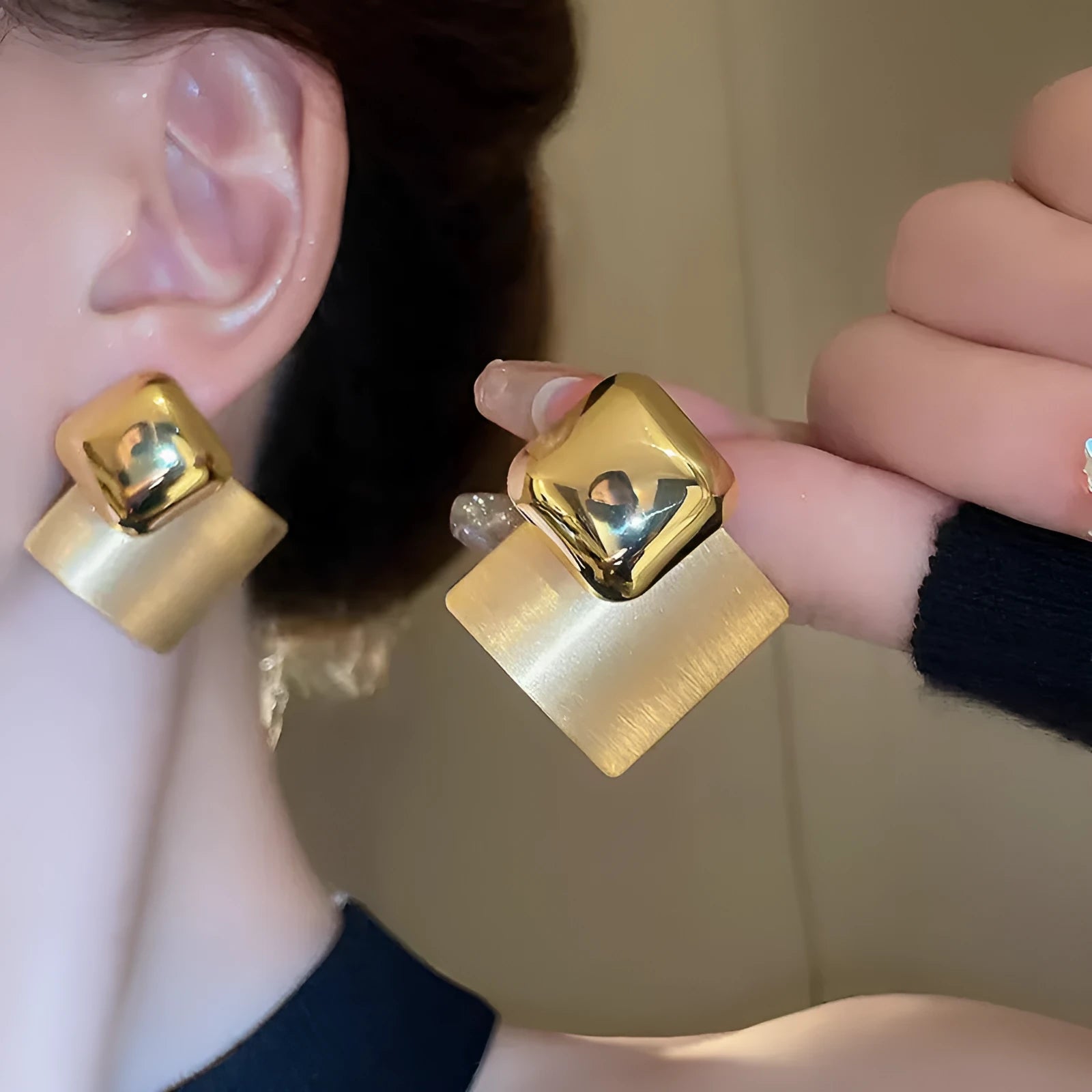 Women's gold brushed square stud earrings with 925 silver needle posts on a light background