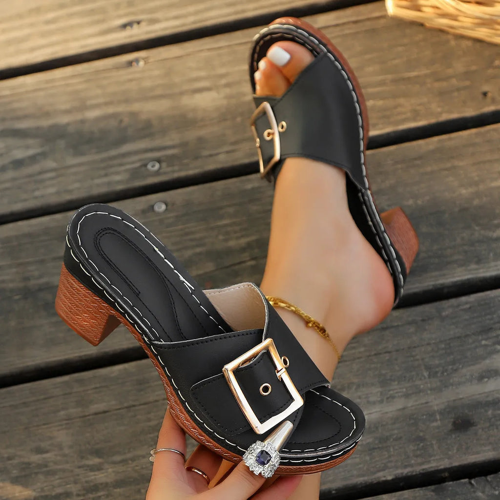 Women's black retro chunky heel slippers with a large metal buckle on the strap.