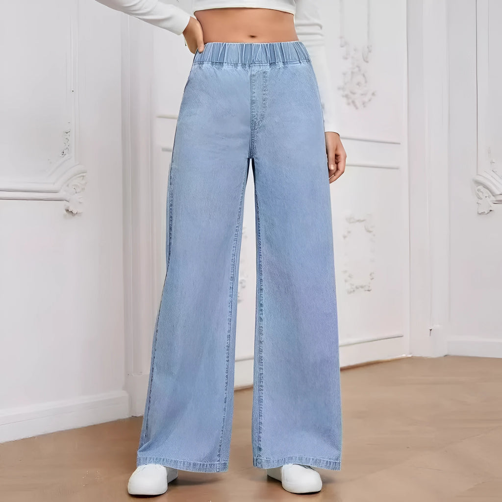 Light blue washed wide-leg denim jeans on a plus-size model, showing straight leg and mid-rise waist.