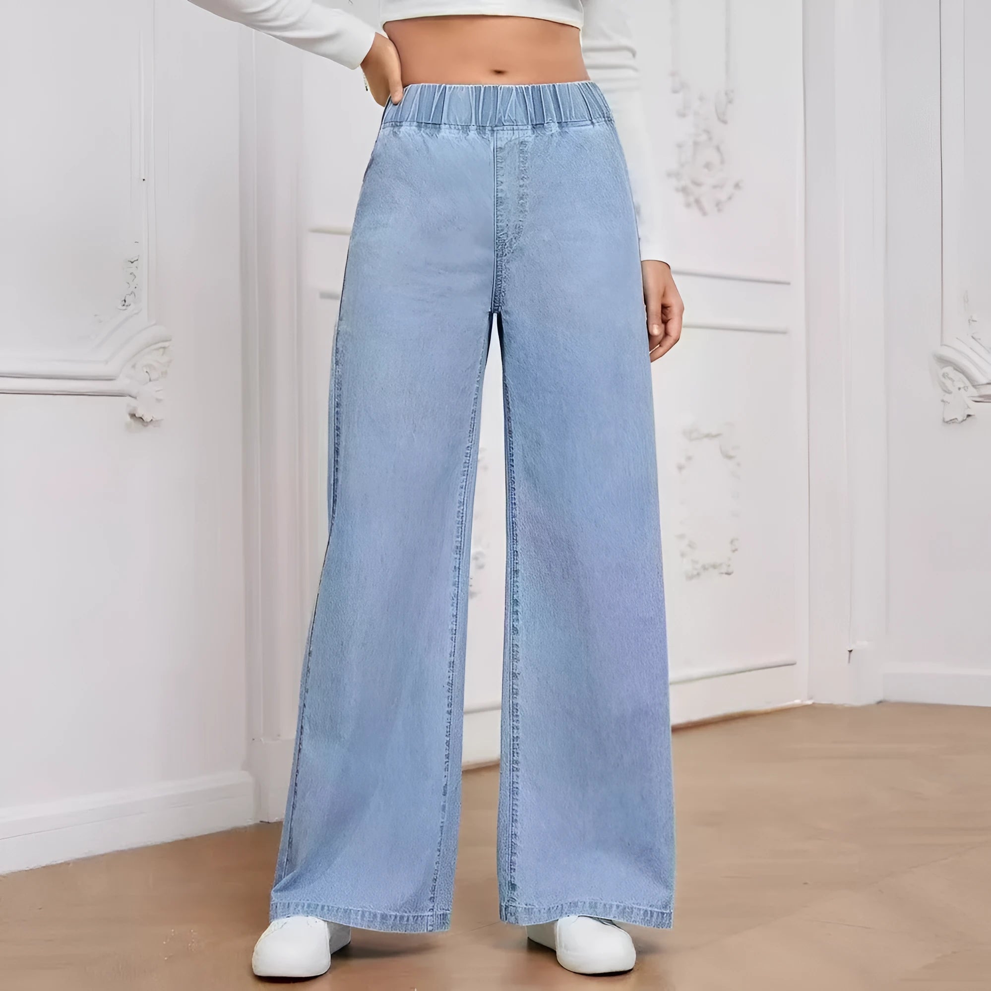 Light blue washed wide-leg denim jeans on a plus-size model, showing straight leg and mid-rise waist.