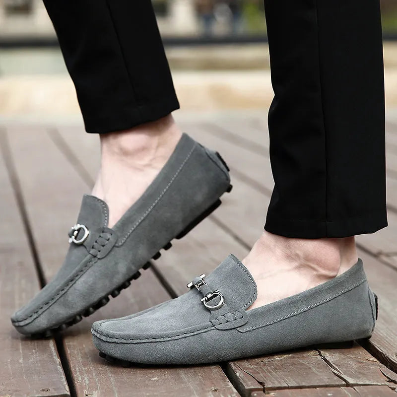 Men's black cowhide leather slip-on shoes with square toe and visible stitching on a rubber sole.