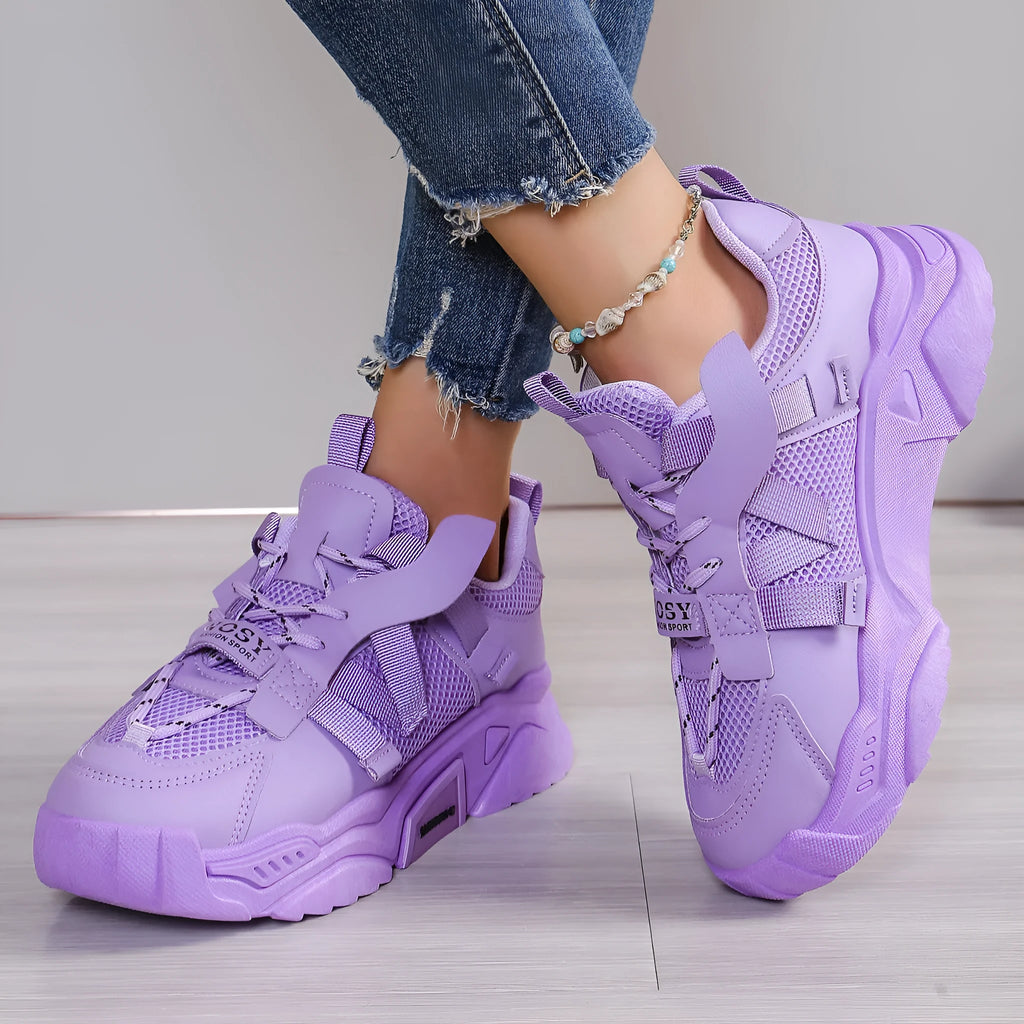 Women's purple and white platform mesh sports sneakers with front lace-up design on a plain background.