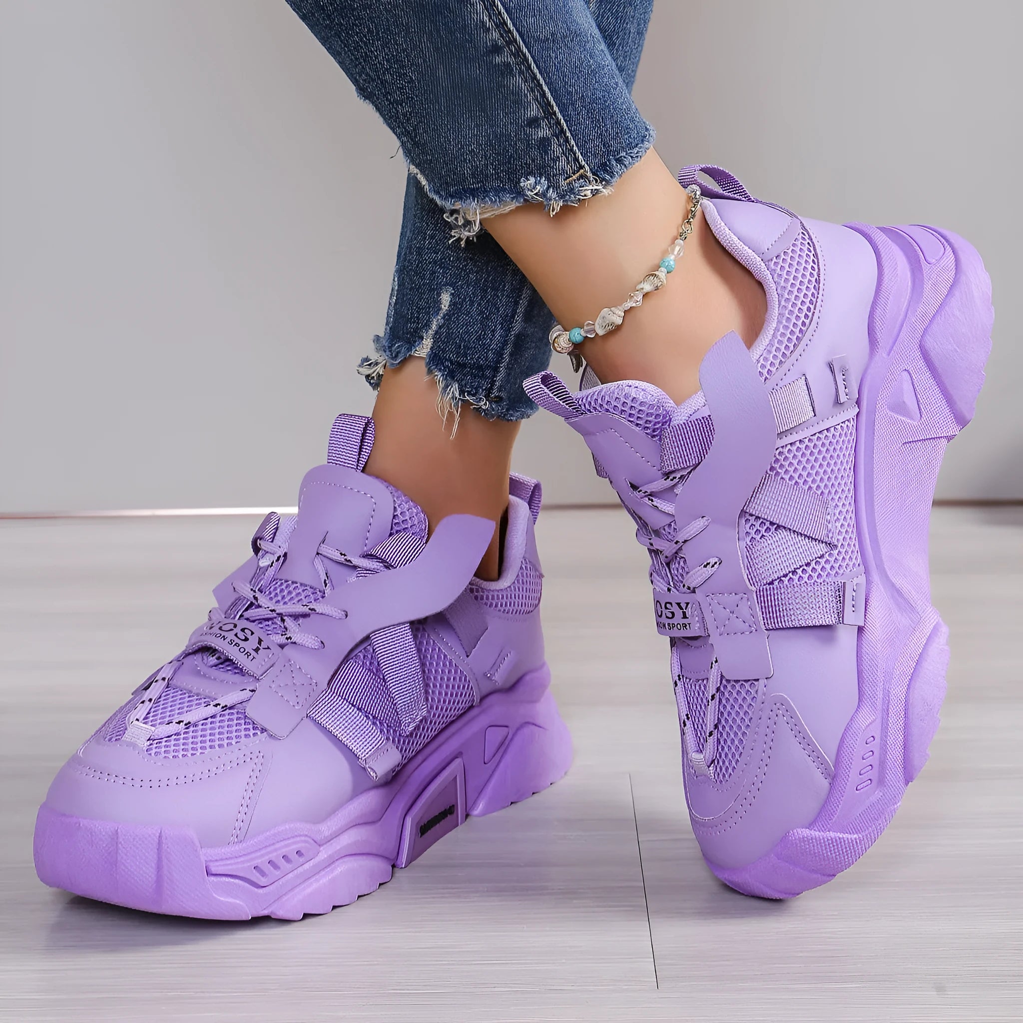 Women's purple and white platform mesh sports sneakers with front lace-up design on a plain background.