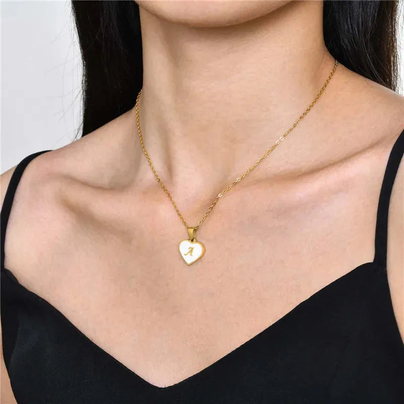 Gold plated heart-shaped necklace with a personalised initial letter and white shell detail on a 50cm adjustable chain.