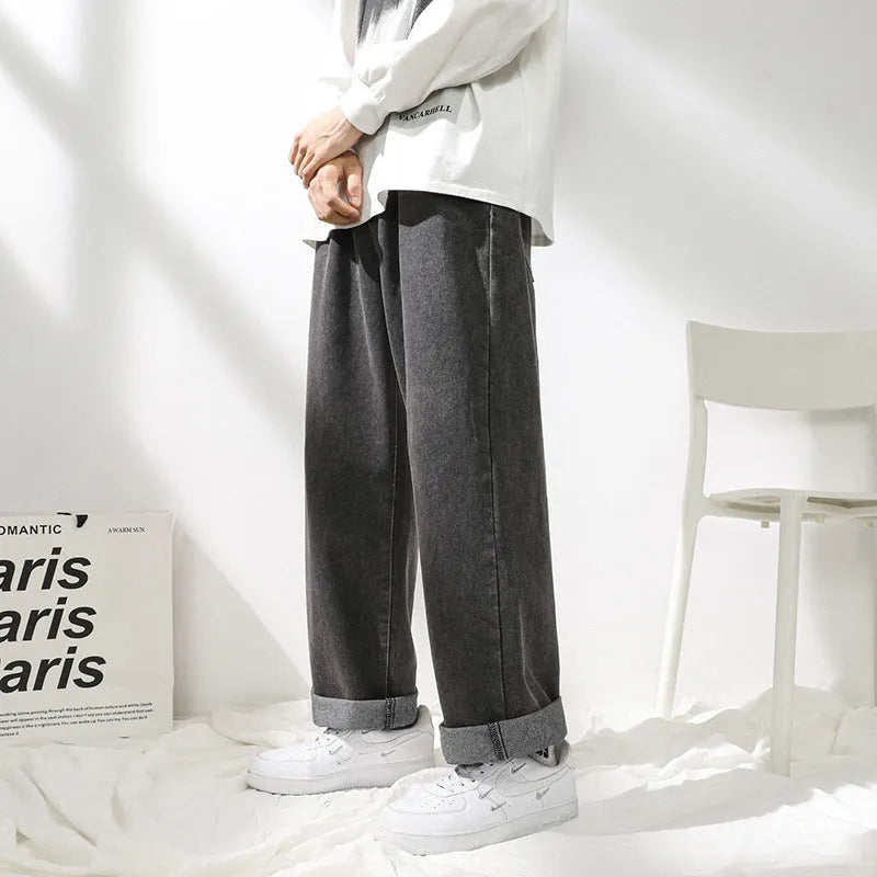 Men's straight loose jeans in black cotton knit fabric with mid waist, shown on a model.