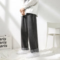 Men's straight loose jeans in black cotton knit fabric with mid waist, shown on a model.