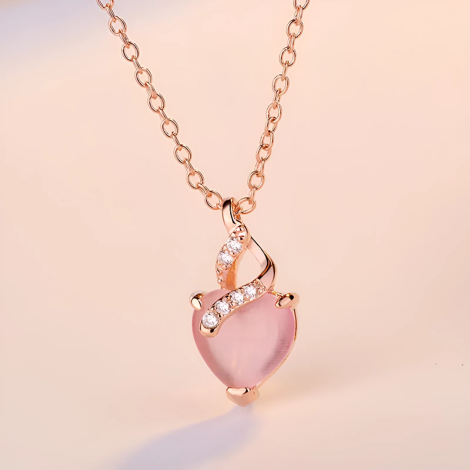 Rose gold necklace with heart-shaped pink crystal pendant and cross chain design