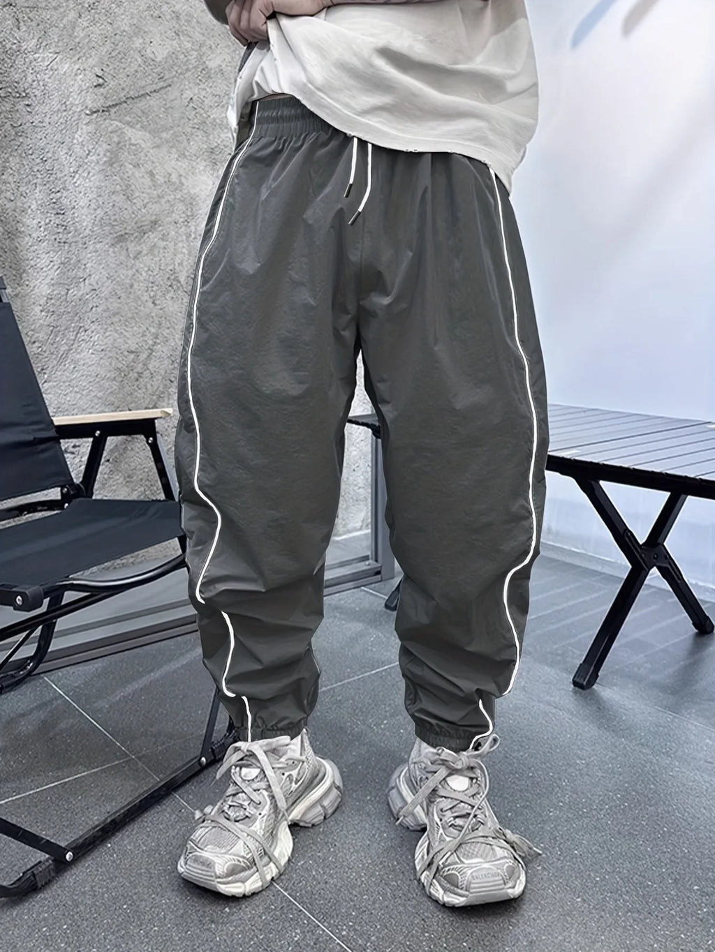 Man wearing blue cropped bamboo fibre sports trousers with a loose, elasticated fit.