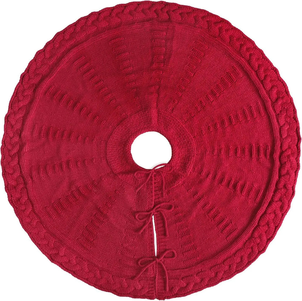 Red knitted wool Christmas tree skirt with 122cm diameter on floor under decorated tree
