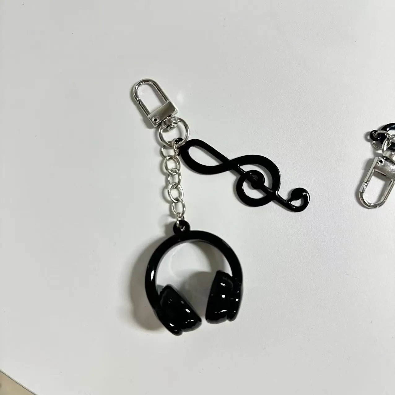 Creative music headset keychain with gradient blue resin earphone pendant and alloy keyring on a plain background